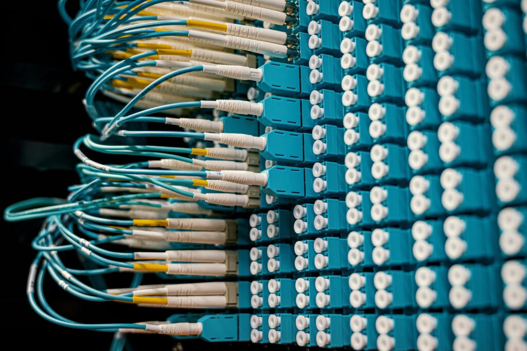 pexels-photo-4339335-4339335 Close-up of a network patch panel with connected blue fiber optic cables.